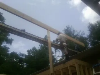 Carpenter setting a ridge beam over a new addition frame — Ice Dam Removal by Roofing Brothers in Panguitch