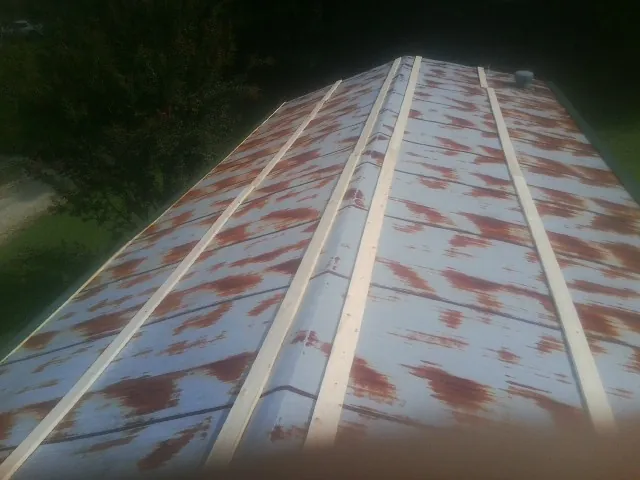 Rusted metal roof panels with new wood purlins before replacement — Storm Damage Roof Repair in Panguitch by Roofing Brothers