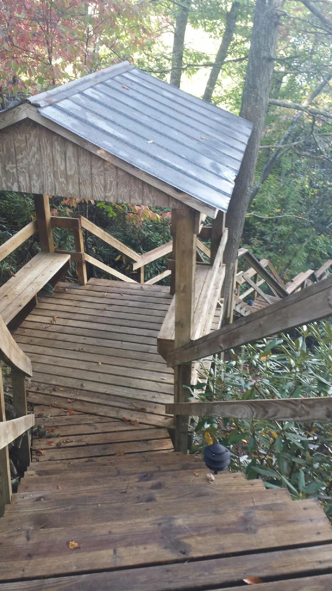 Metal roofed shelter over wooden steps on a wooded walkway — Skylight Repair & Installation work by our crew in Panguitch