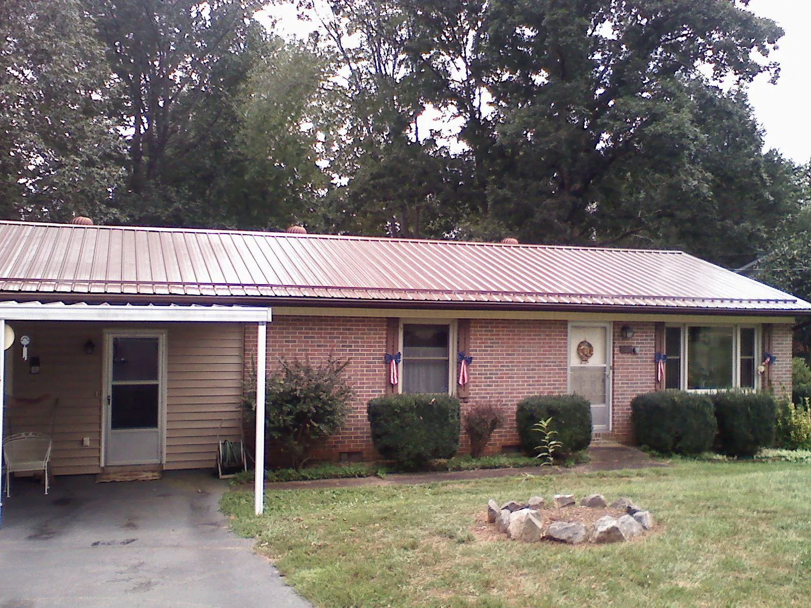 Bronze metal roof and carport on a brick ranch home — Roof Repair work by our crew in Panguitch